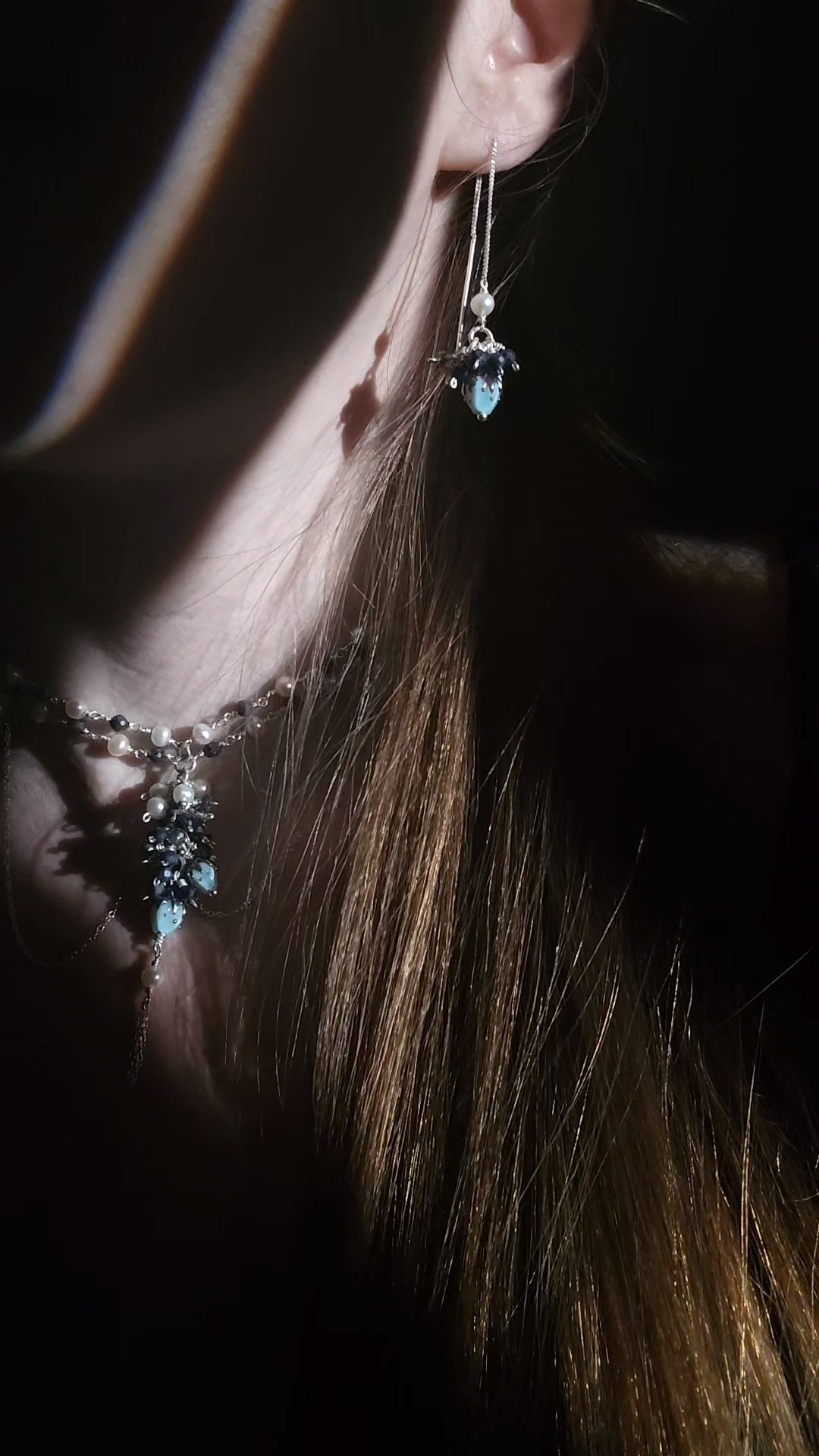 girl wearing blue necklace and earrings